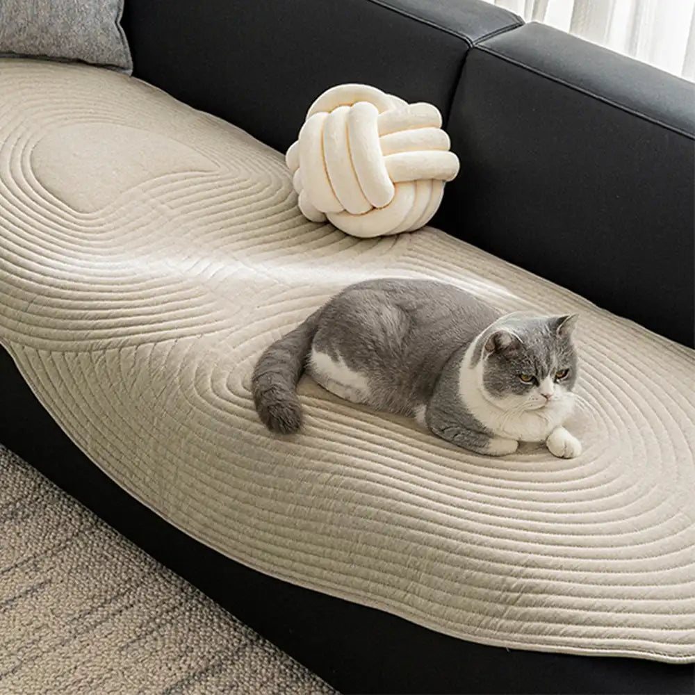 Soft cotton couch cover draped over a gray sofa, showcasing its snug fit