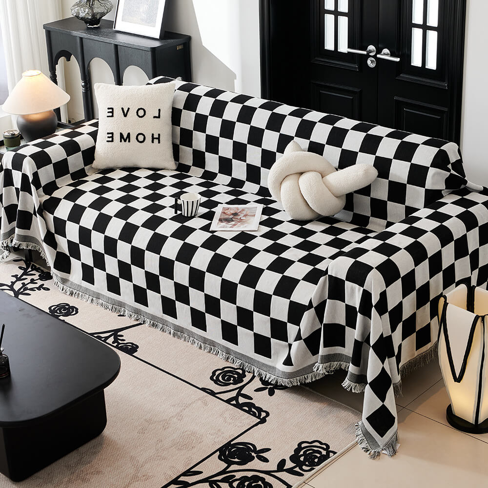 Checkerboard throw blanket with fringe trim on a sofa