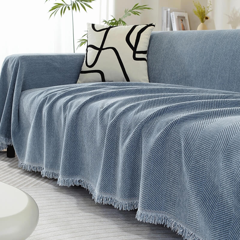Luxury Chenille Throw Blanket on a sofa, showcasing its herringbone design and tassel details.