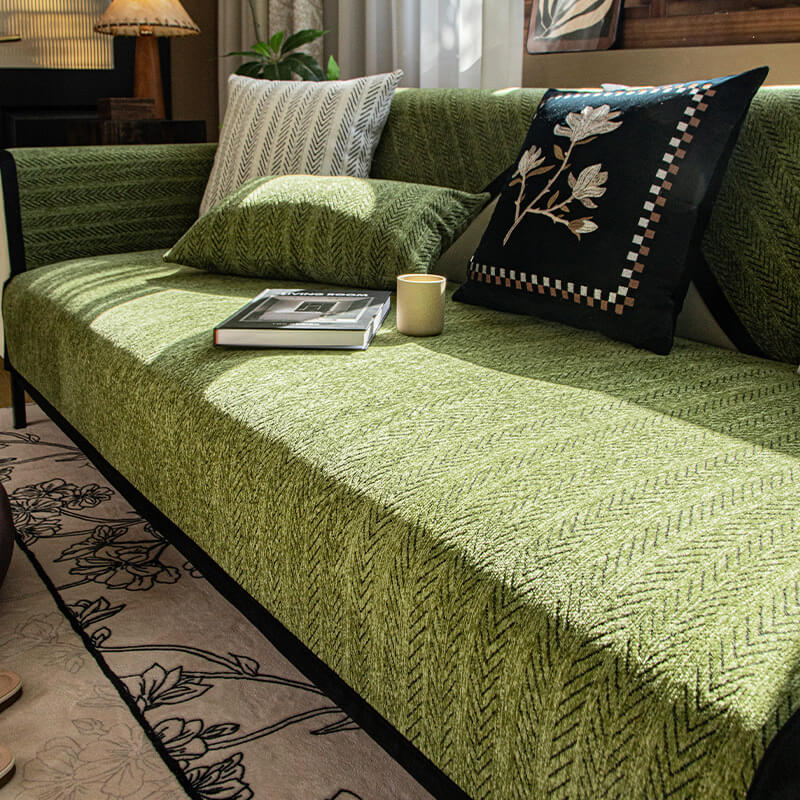 Close-up of chenille fabric sofa cover draped over a leather couch