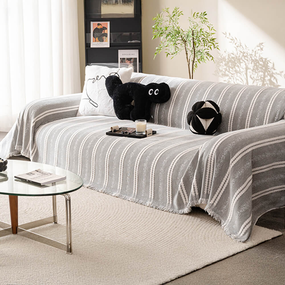 Stylish chenille sofa cover with tassels protecting a modern sofa