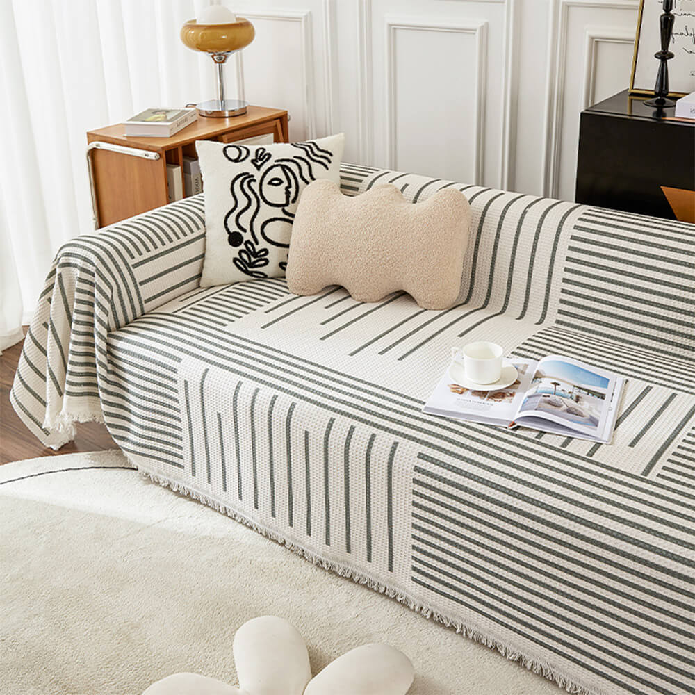 View of a geometric pattern sofa cover draped over a modern couch, showcasing its vibrant colors.