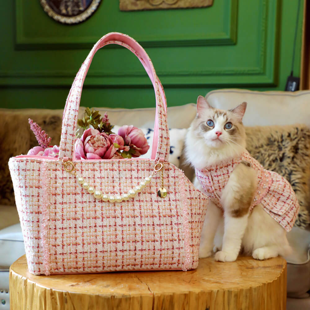 Luxury tweed pet carrier with pearl accents, shown carried by a fashion-forward owner