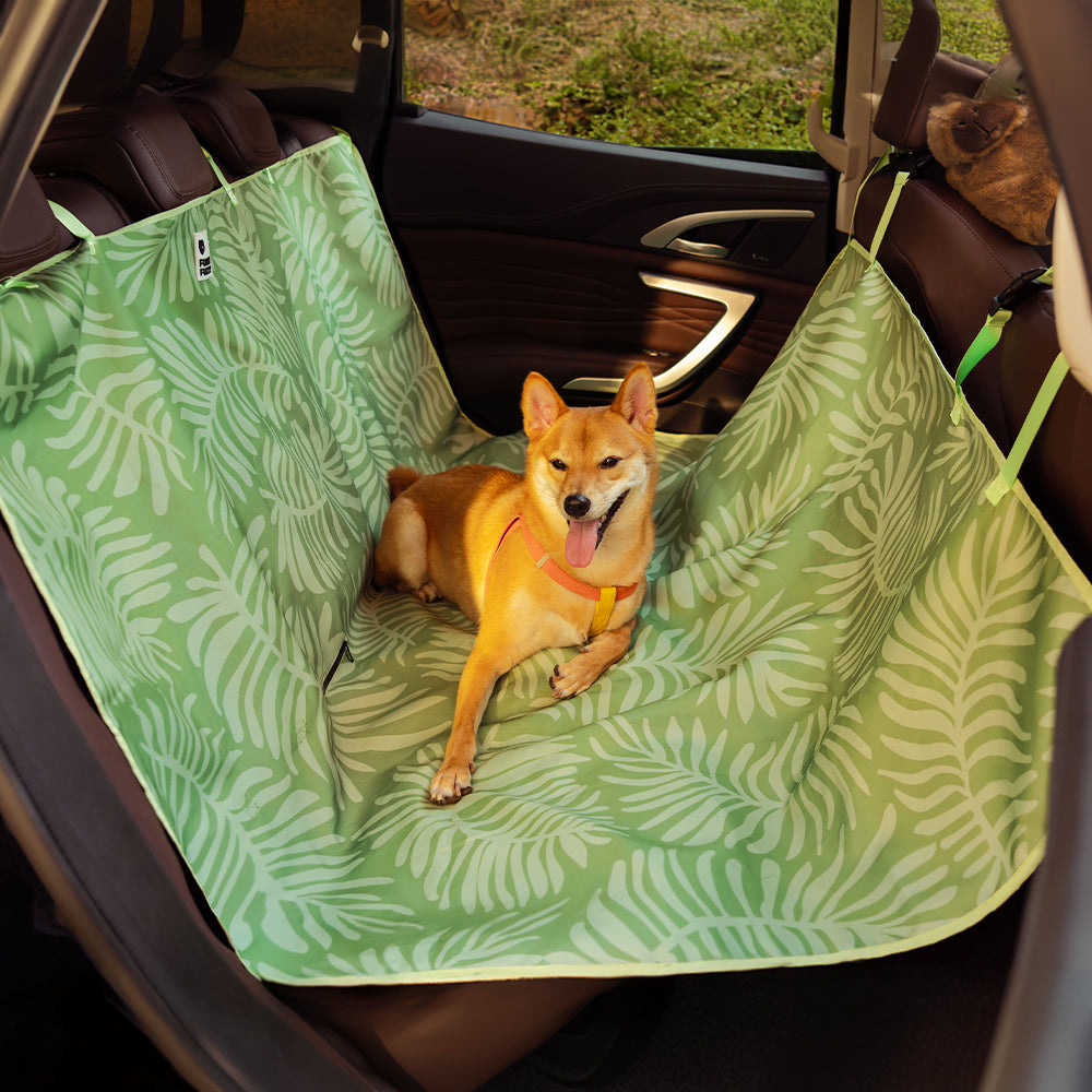 Close-up of waterproof car seat cover with vibrant tropical pattern stretched over backseat