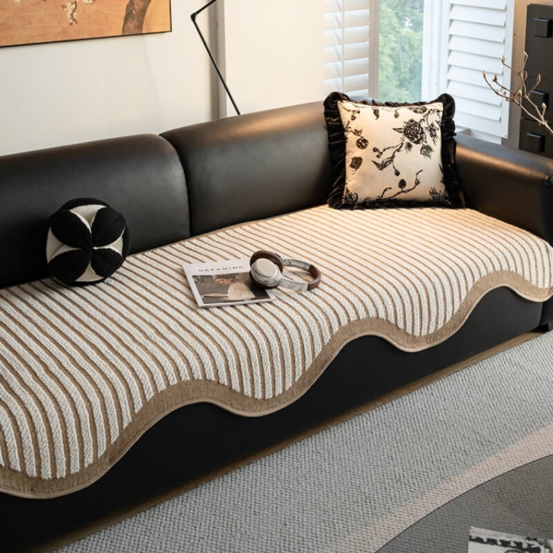 Front-facing view of striped chenille sofa protector on beige couch, showcasing non-slip design