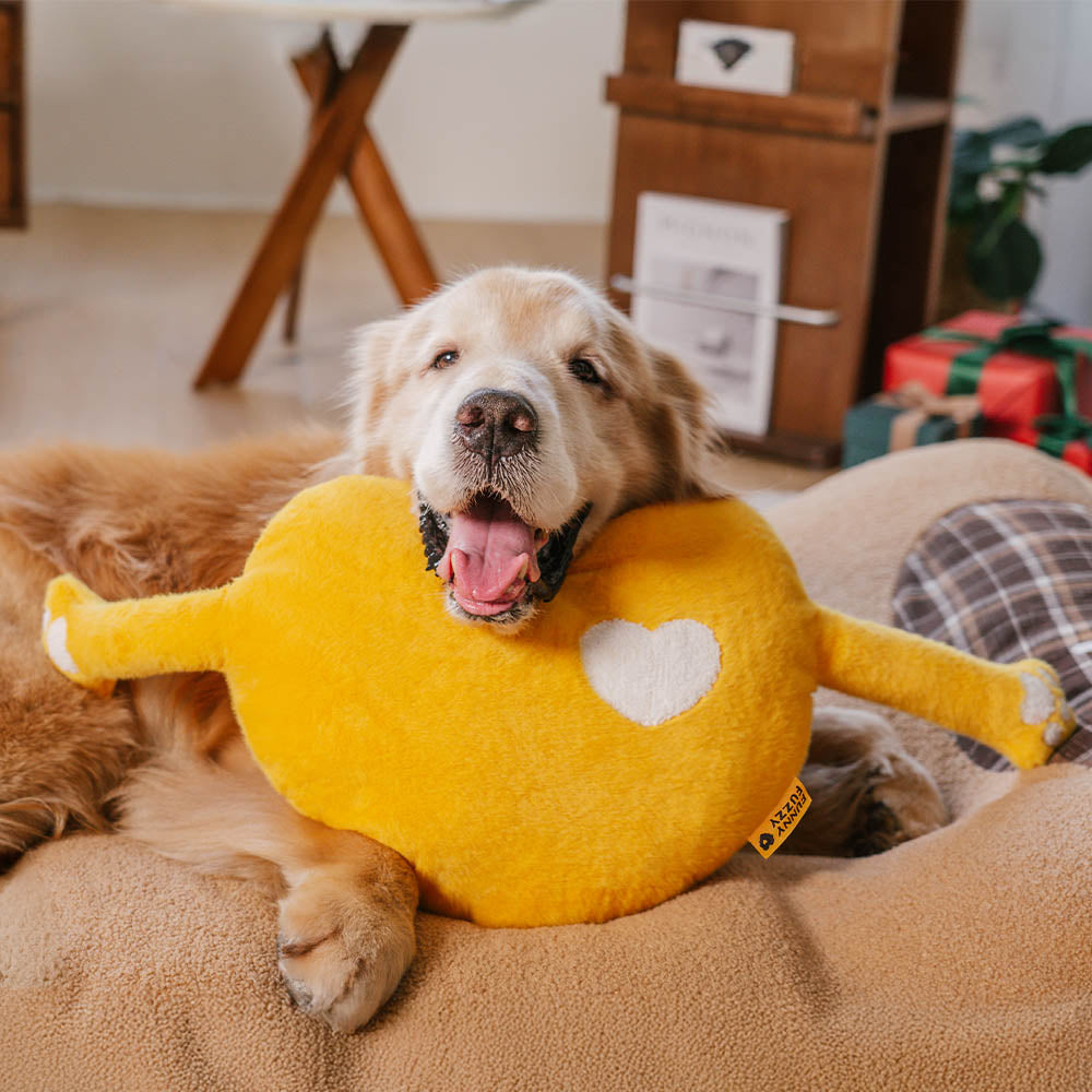 Front view of heart pillow with extended cozy arms on a decorative bed setting