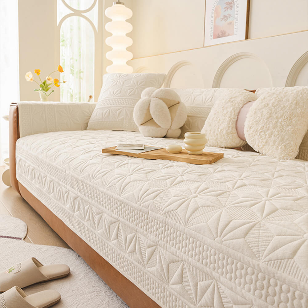 Front angle view of the CrystalVel LuxeGrip™ couch cover showing quilted velvet texture on beige sofa