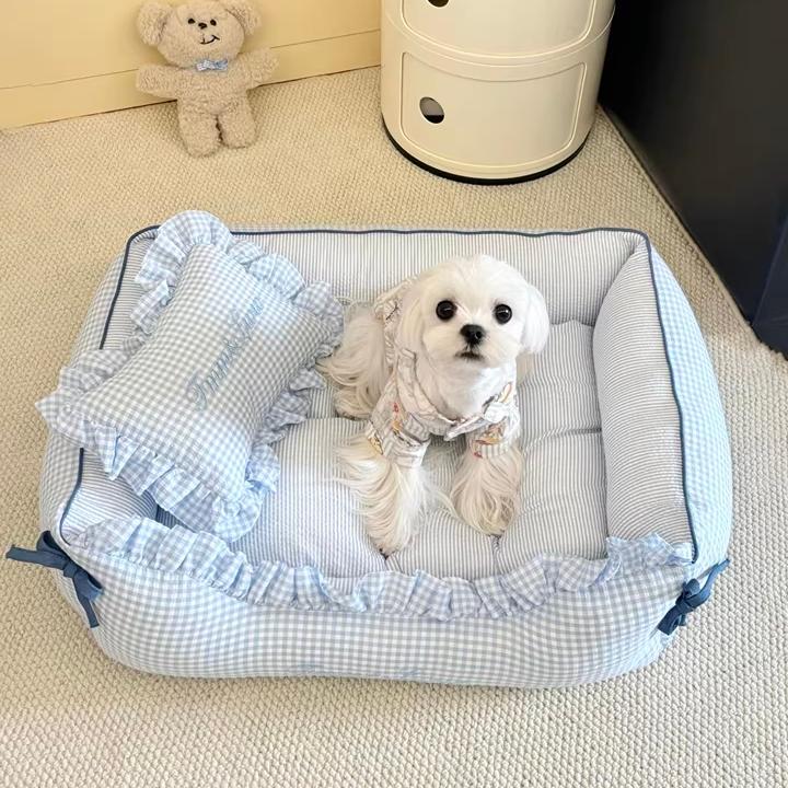 Soft gingham pet sofa bed with ruffled trim, placed in a living room
