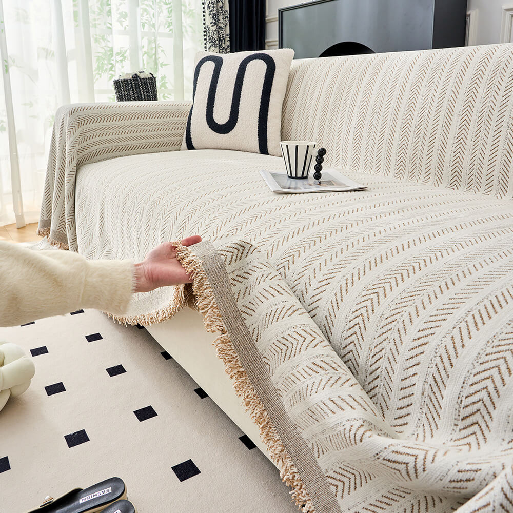 A soft herringbone chenille couch cover draped elegantly over a light grey sofa, showcasing its texture and pattern.