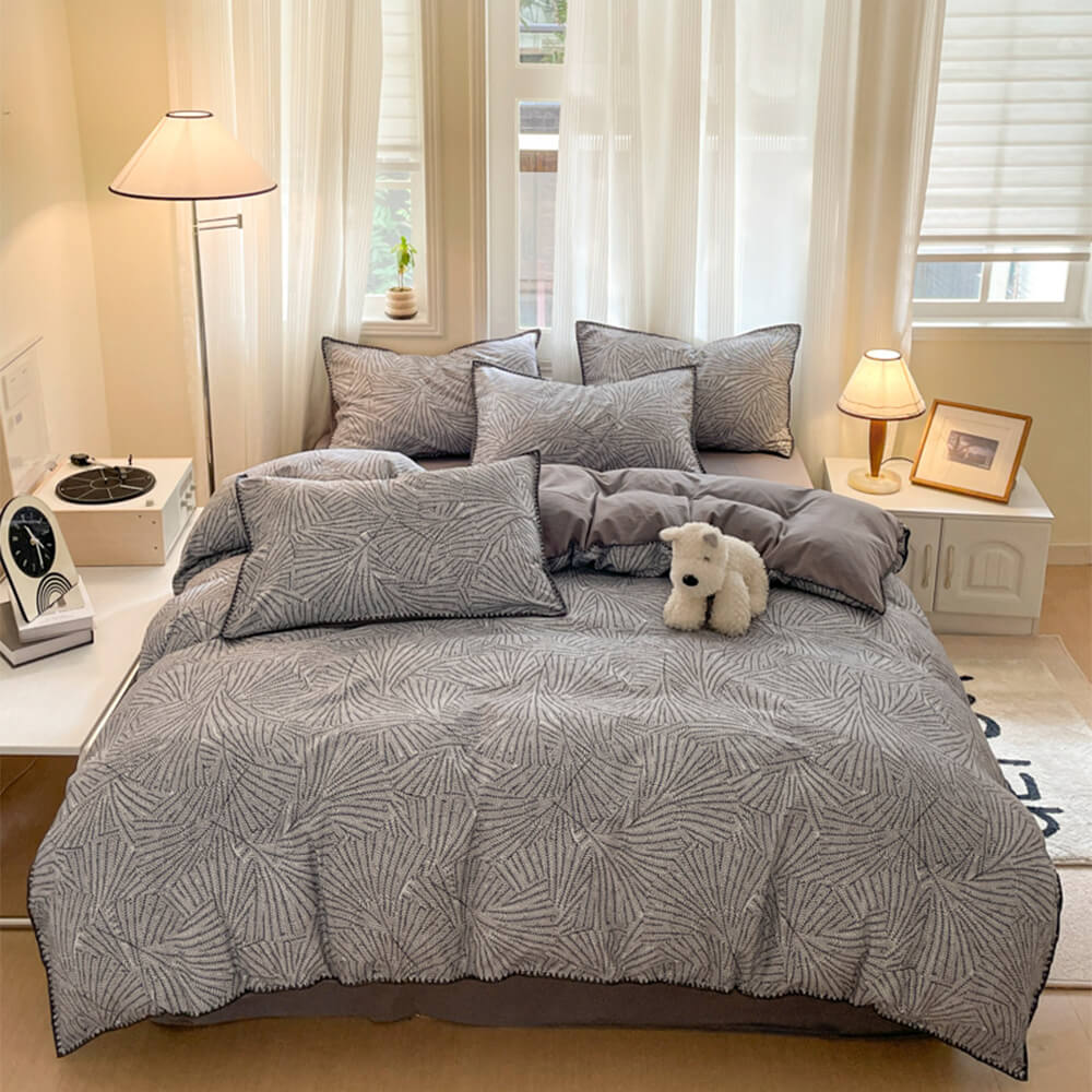 Top view of leaf print bedding styled on a queen size bed in soft winter lighting.