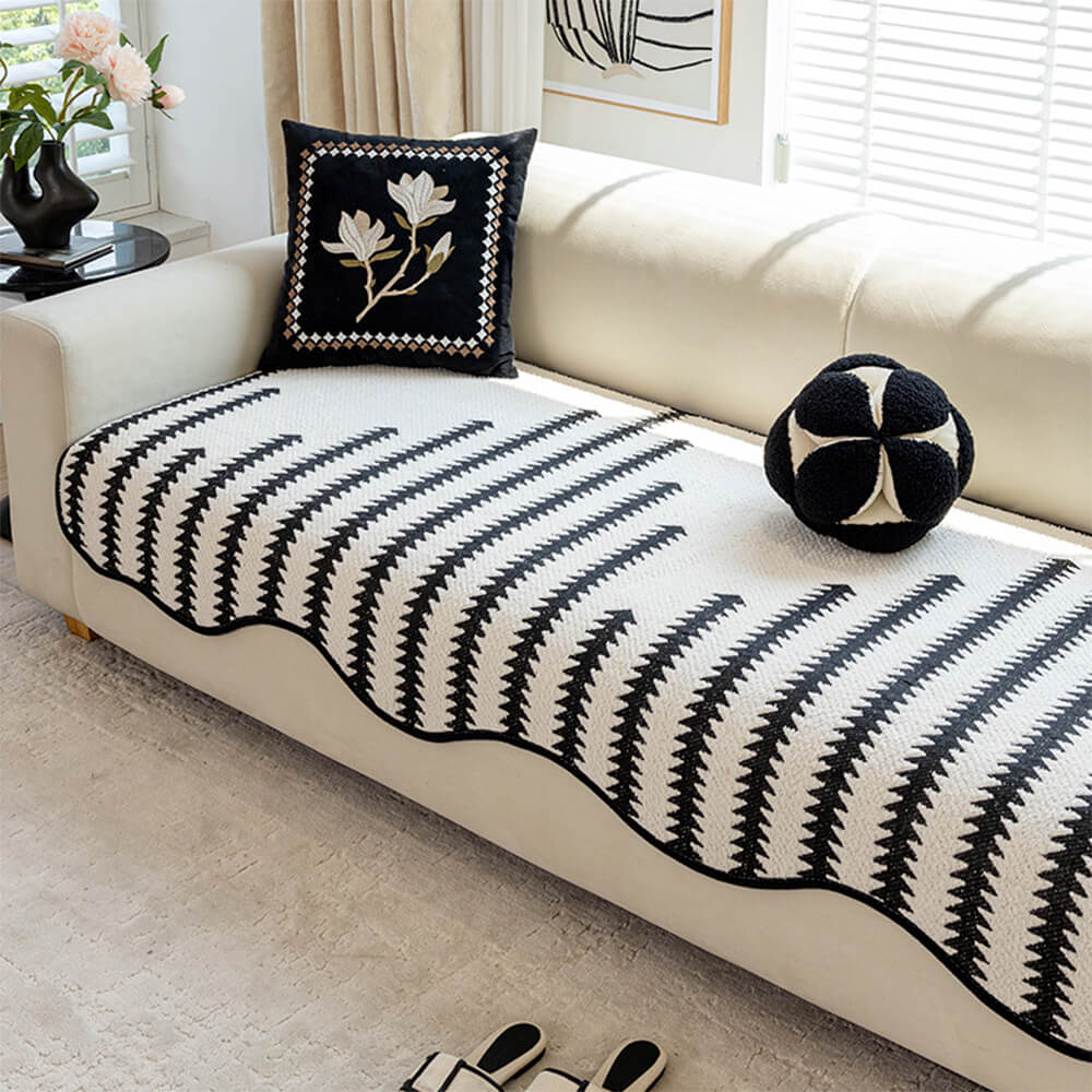 Modern chevron sofa cover with wavy edges on a living room couch