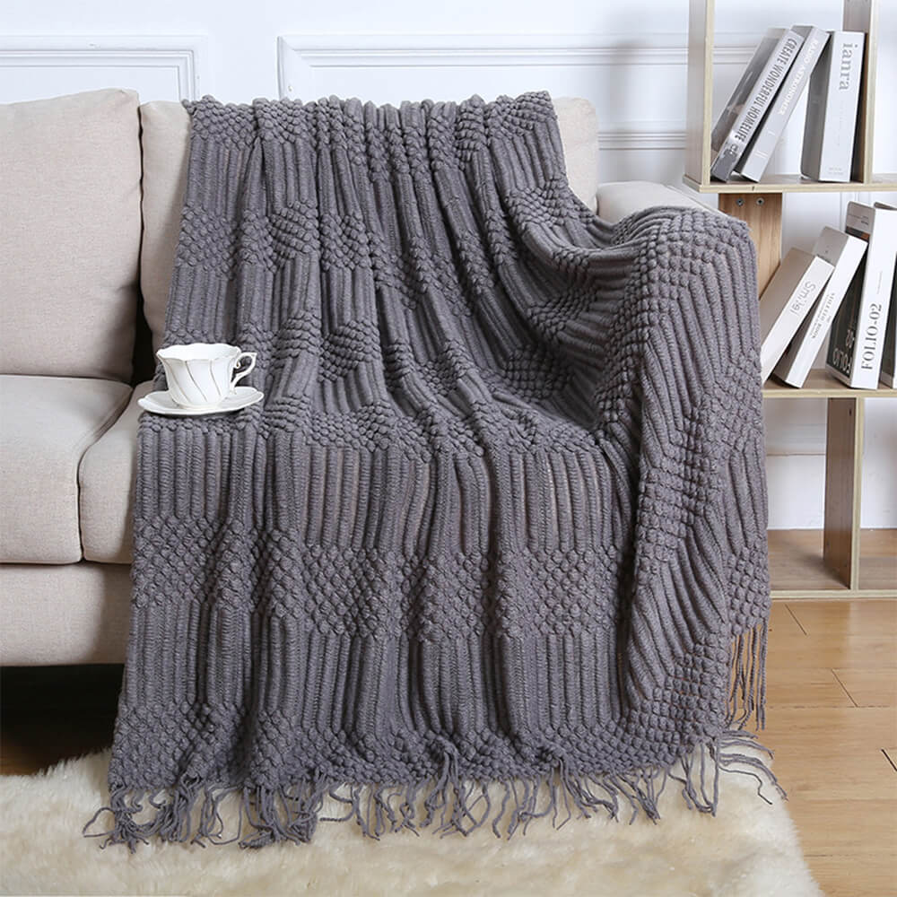 Close-up of soft fleece blanket with fringed edges on a sofa