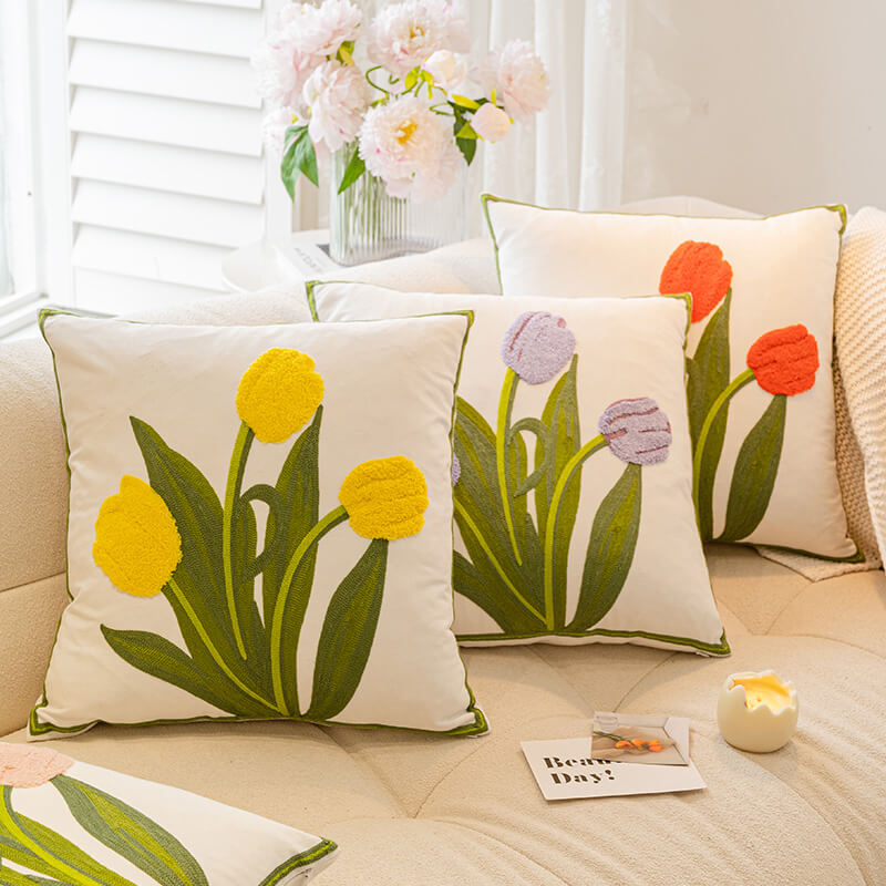 Close-up of vibrant tulip and sunflower floral cushion highlighting embroidery details