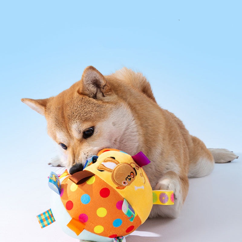 Close-up of embroidered dog squeaky ball showing colorful animal embroidery