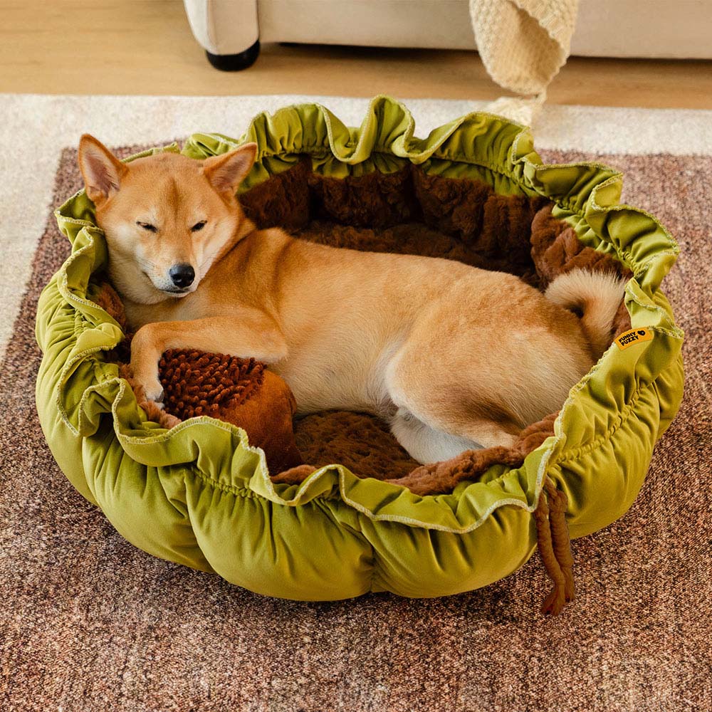 Top-down view of the plush forest-themed adjustable dog bed, shaped like a nest and styled with a leaf-shaped toy.