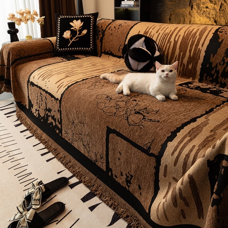 Vintage chenille sofa cover draped over a sectional couch, showcasing its textured fabric and retro pattern.