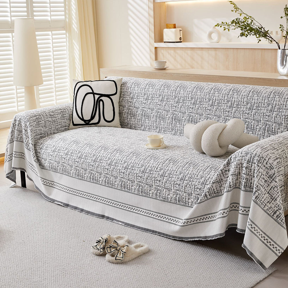 Durable ice silk sofa cover draped over a modern gray couch, showcasing its snug fit and elegant texture.