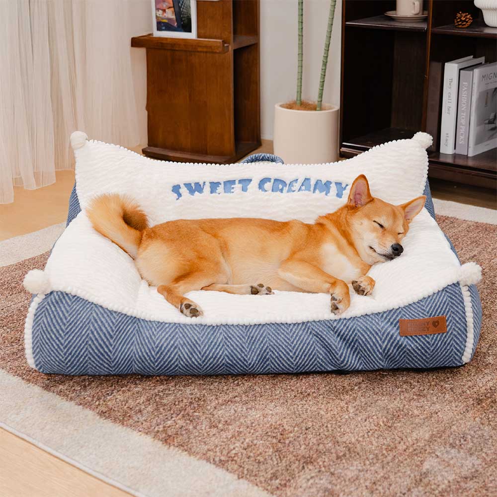 A cozy creamy dog bed with a plush bolster, seen from a high angle, perfect for a sleeping dog.