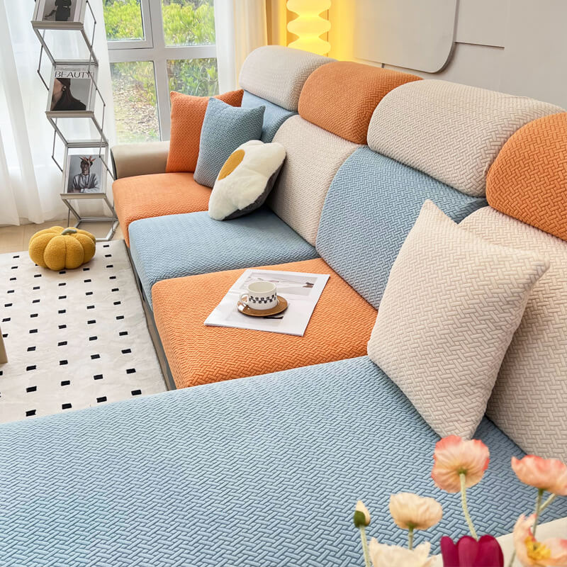 Fleece sofa cover being stretched over a couch to demonstrate its elasticity and fit.