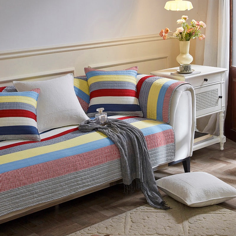 Stylish quilted sofa protector with vibrant striped pattern, perfect for pet owners.