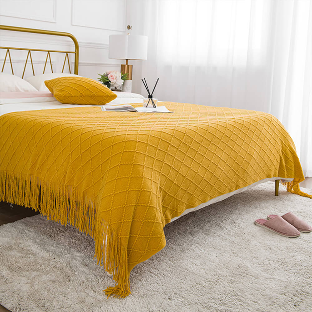 Chic tassel knitted sofa blanket draped over a couch, showcasing its elegant design.