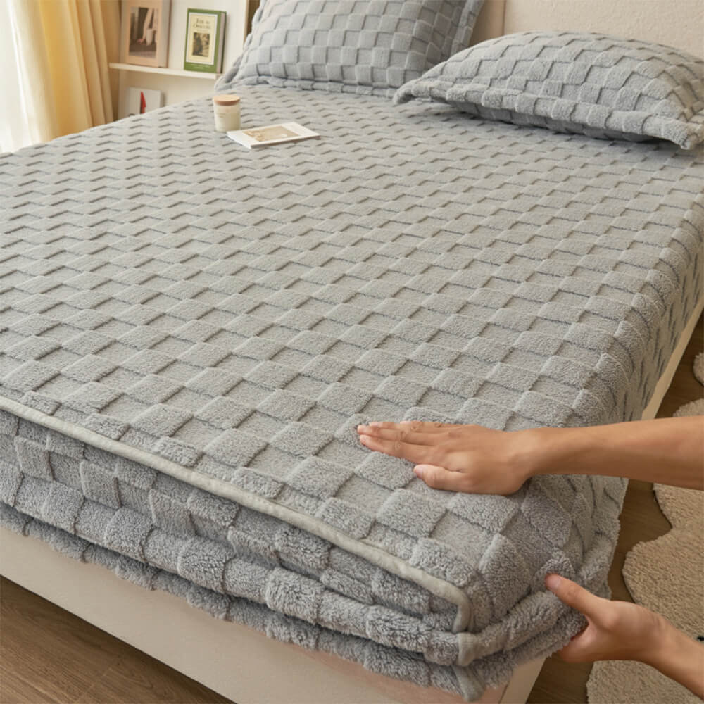 Overhead view of plush checkerboard fitted sheet on queen-sized bed with warm lighting
