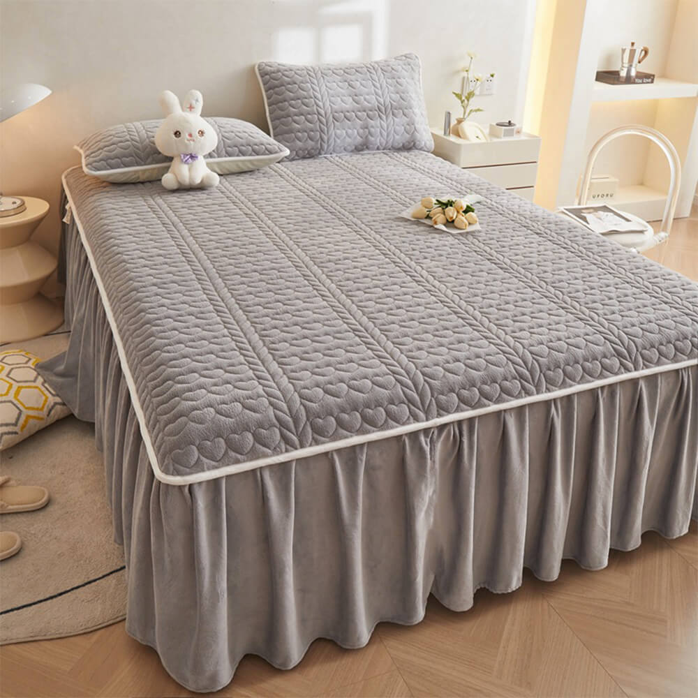 Top-down view of creamy velvet quilted bed skirt set styled in a modern minimalist bedroom