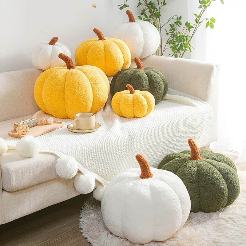 Soft teddy fleece pumpkin pillow on a cozy sofa, perfect for fall decor.