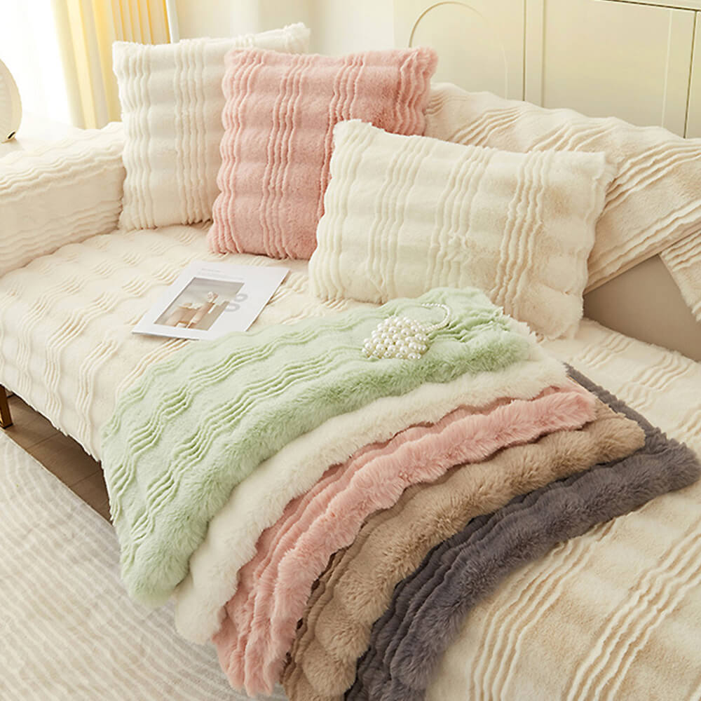 Overhead view of faux fur couch cover styled on a neutral-toned sofa with pillows.
