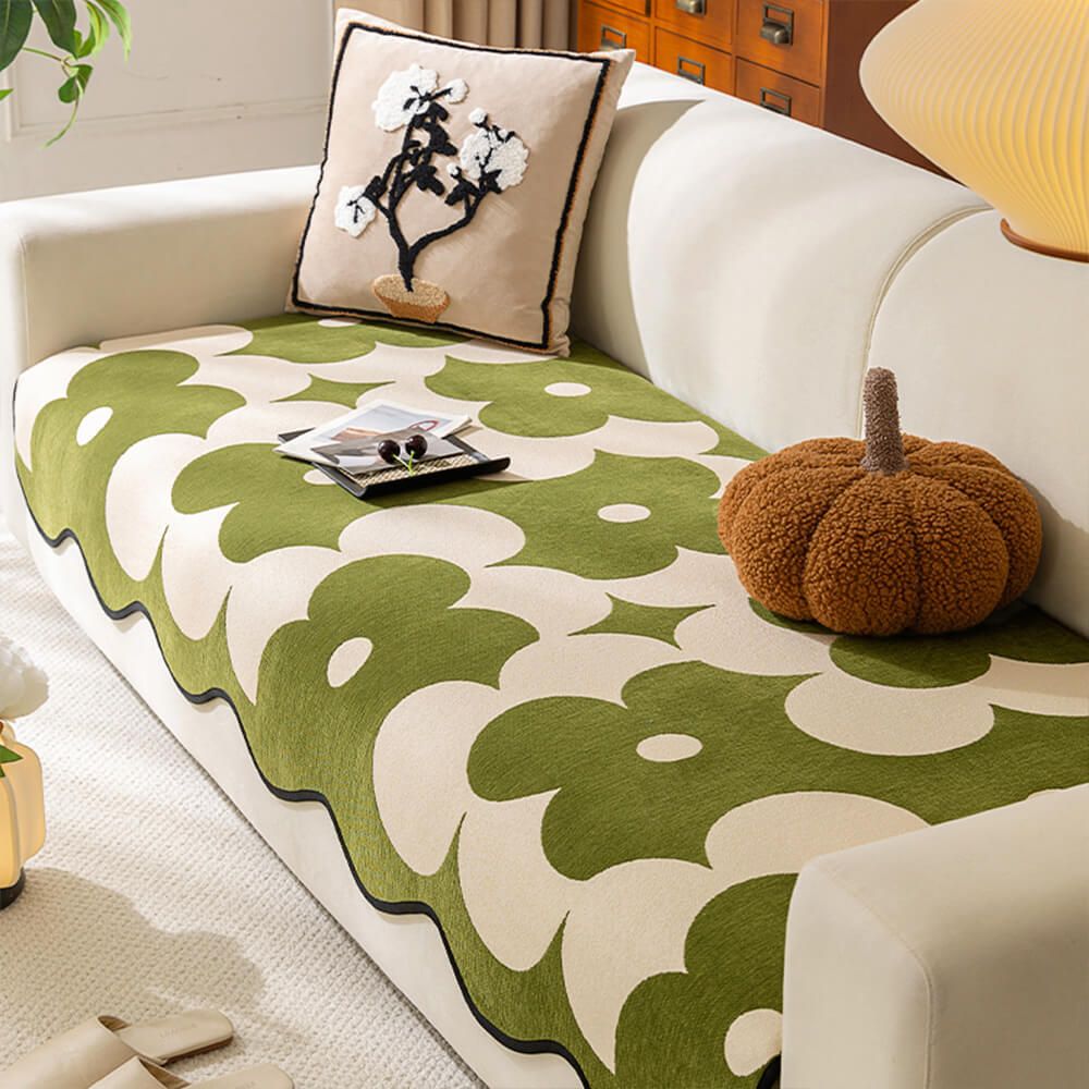 Elegant black and white floral chenille sofa protector draped over a light-colored couch in a modern living room, showcasing its full design.