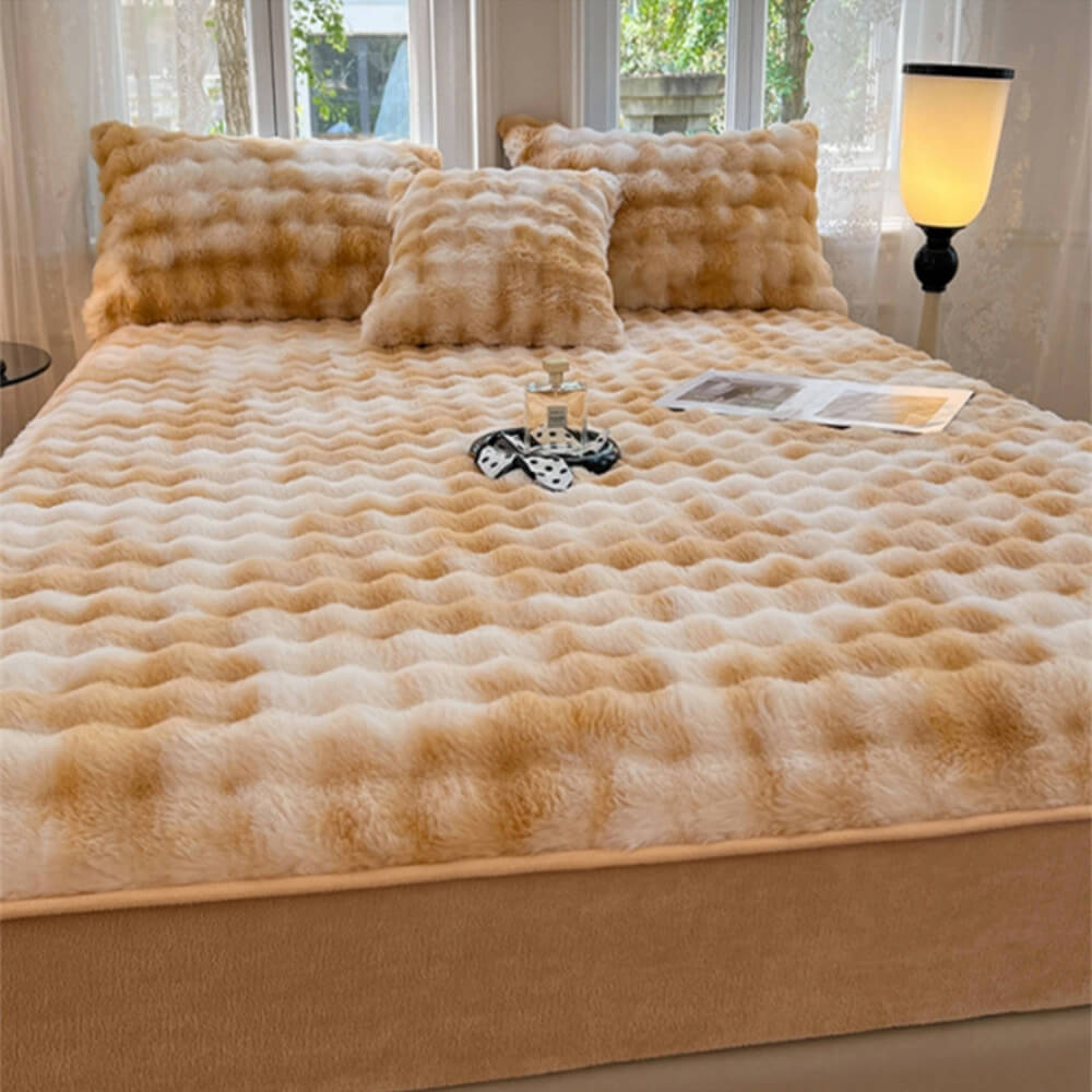 Close-up of gradient cream faux fur mattress cover on bed