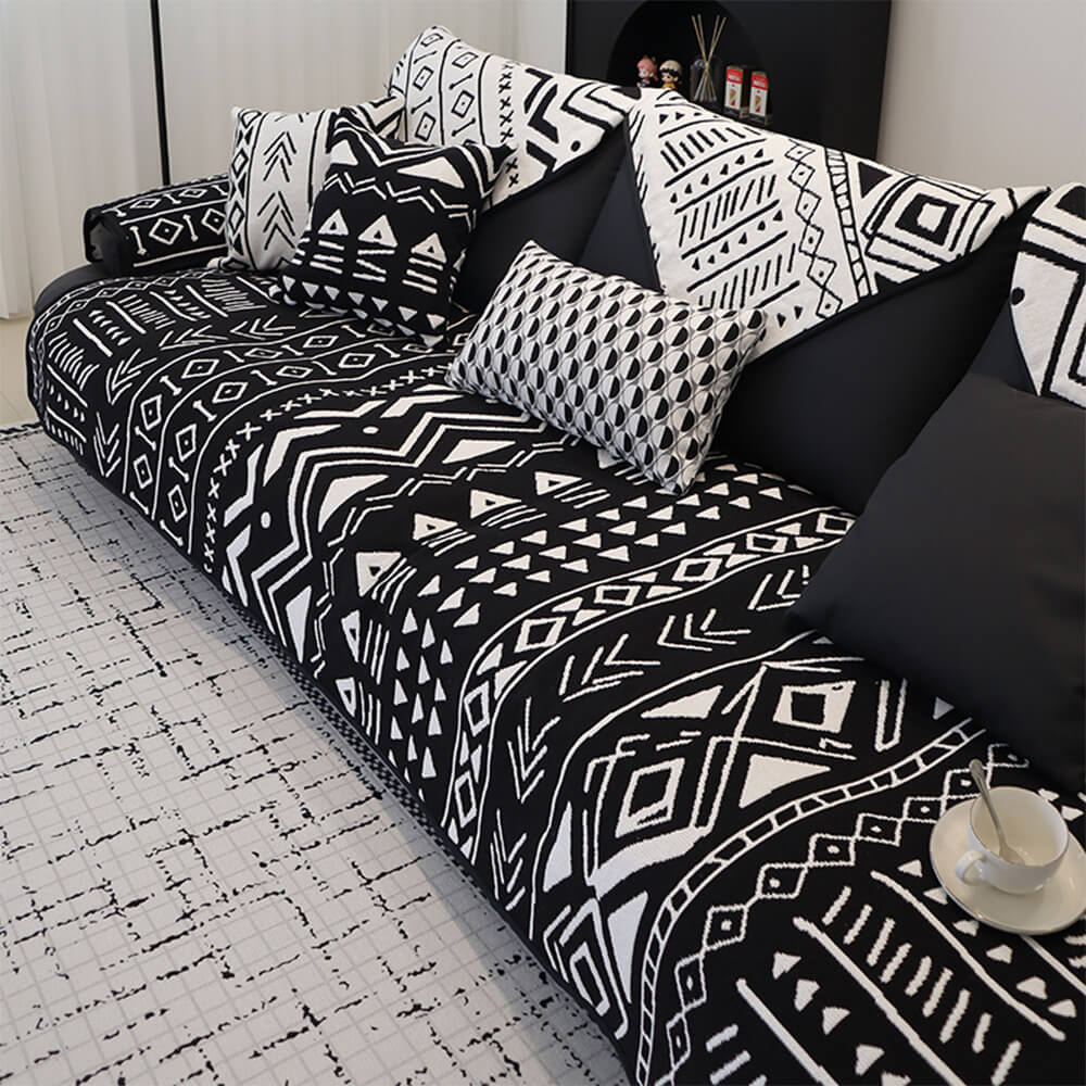 Bohemian geometric couch cover draped over a gray sofa, showcasing boho patterns