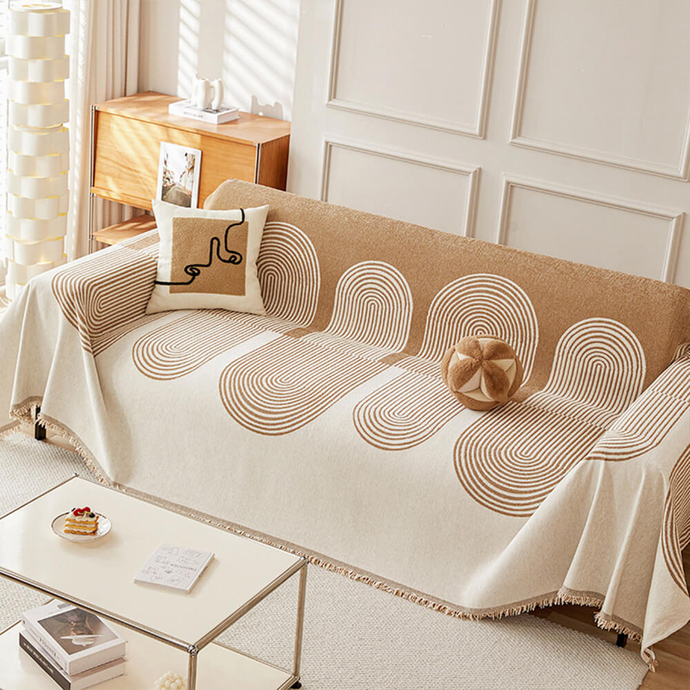 Close-up of reversible chenille sofa cover with geometric pattern showing fabric texture and fringed edges