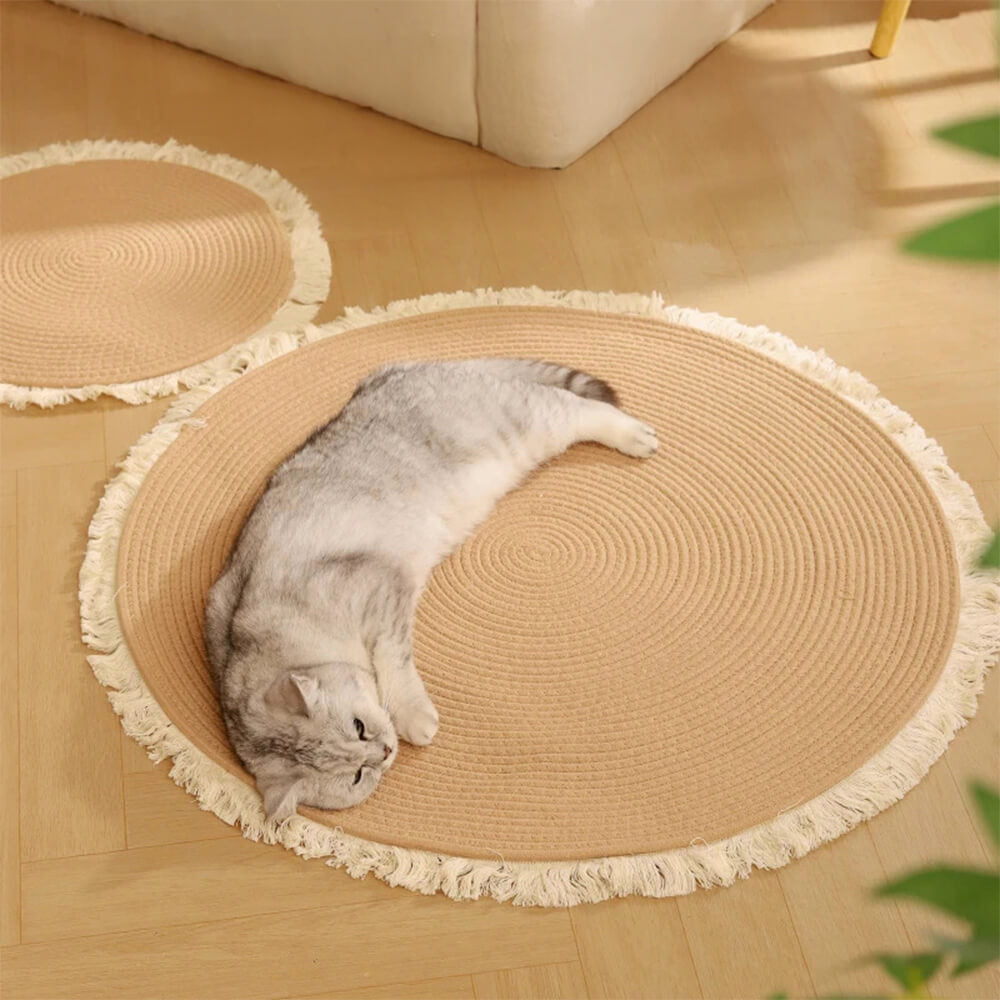 Top view of the round handwoven cat rug with fringe detailing, placed in a modern reading nook.