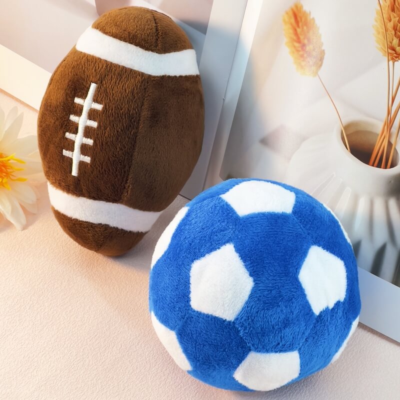 Football shaped dog toy being squeezed by a dog's jaws, highlighting its durability