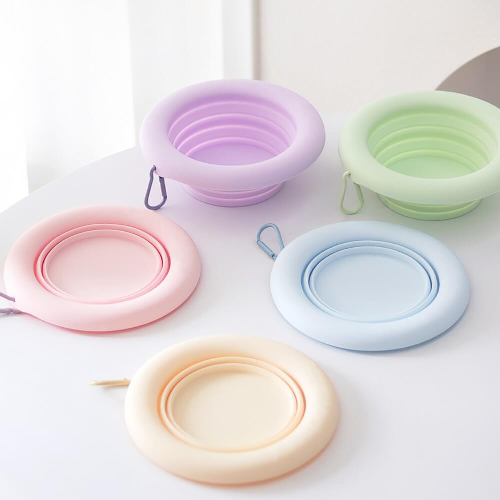 Foldable silicone pet bowl clipped to backpack during outdoor hike
