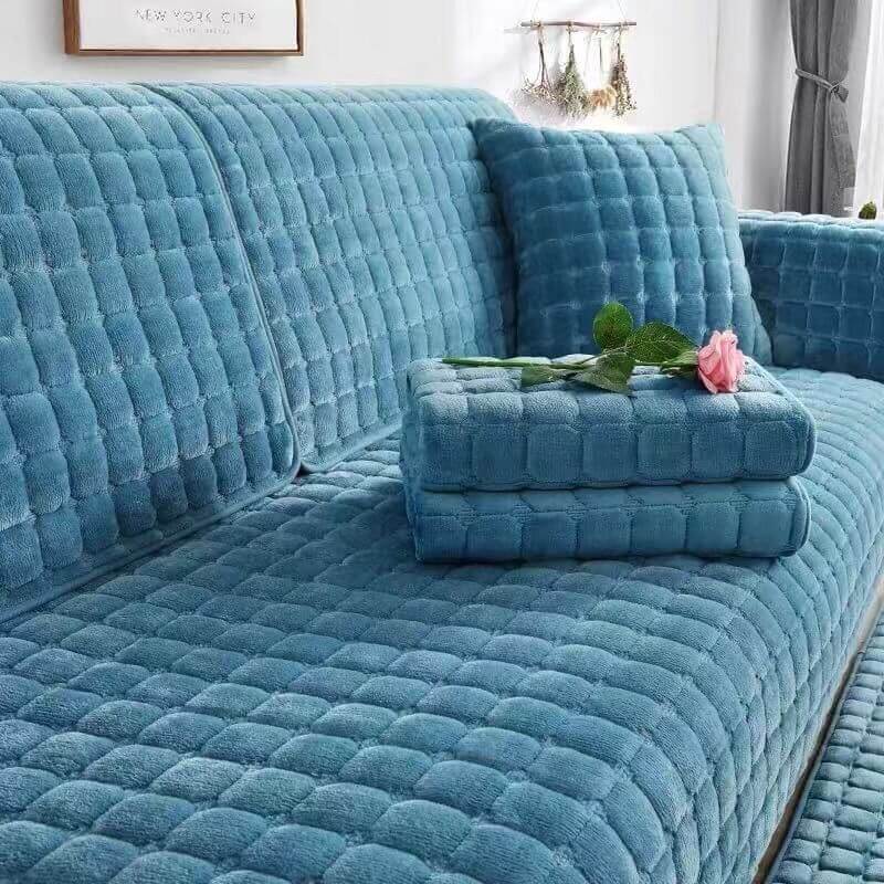 CozyGuard Quilted Flannel Couch Cover on a leather sofa