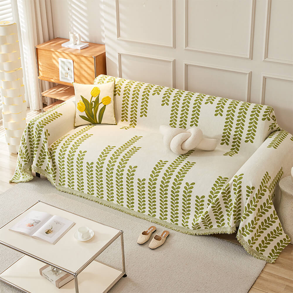 Top view of LeafCharm fringe sofa cover on a beige couch with sunlight filtering through