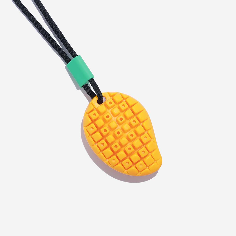 A vibrant yellow mango-shaped suction cup dog toy firmly attached to a smooth floor, showcasing its strong suction power for tug of war.