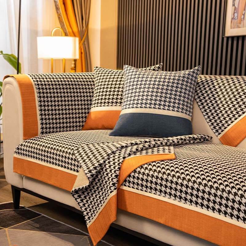 Chenille sofa cover on a leather couch, showcasing houndstooth pattern and snug fit.