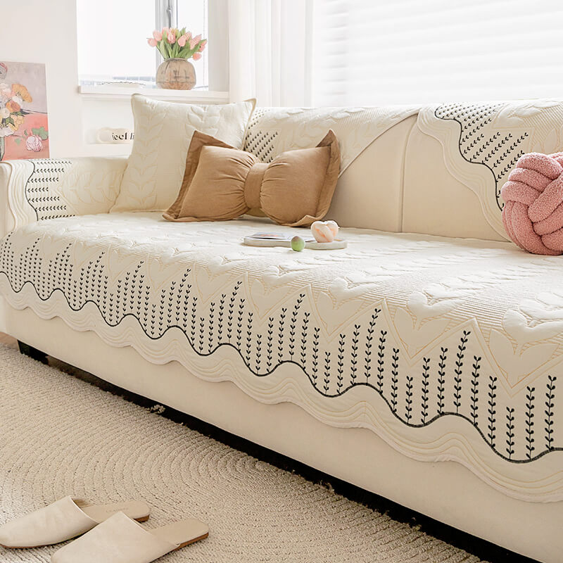 Cream leaf pattern sofa cover protecting a couch from pet scratches