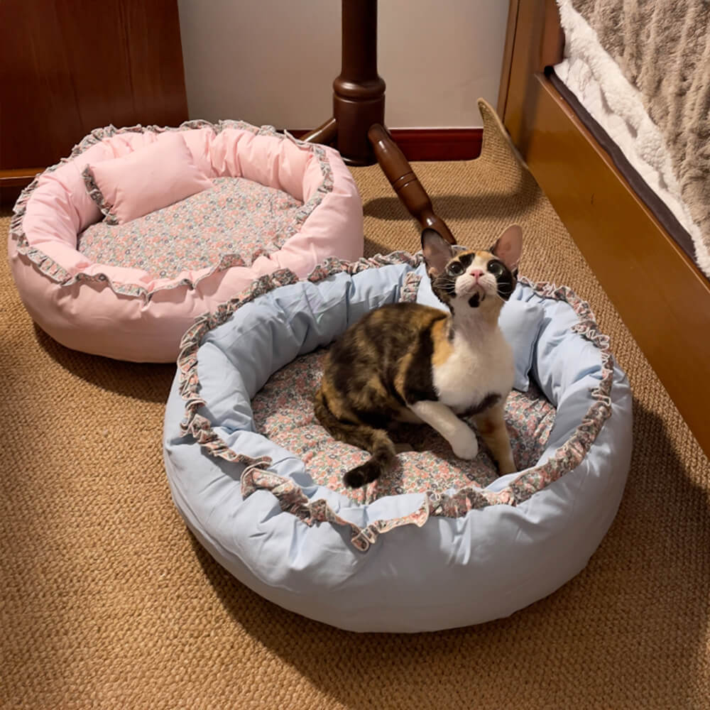 Close-up of vintage floral round cat bed with plush interior and ruffled edges
