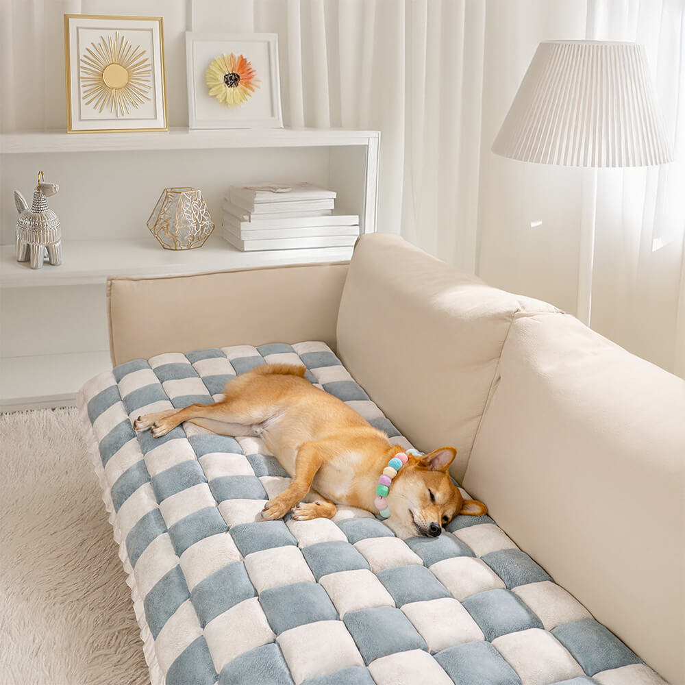 Top-down view of plaid pet mat on a modern couch, showcasing its scratch resistant texture.