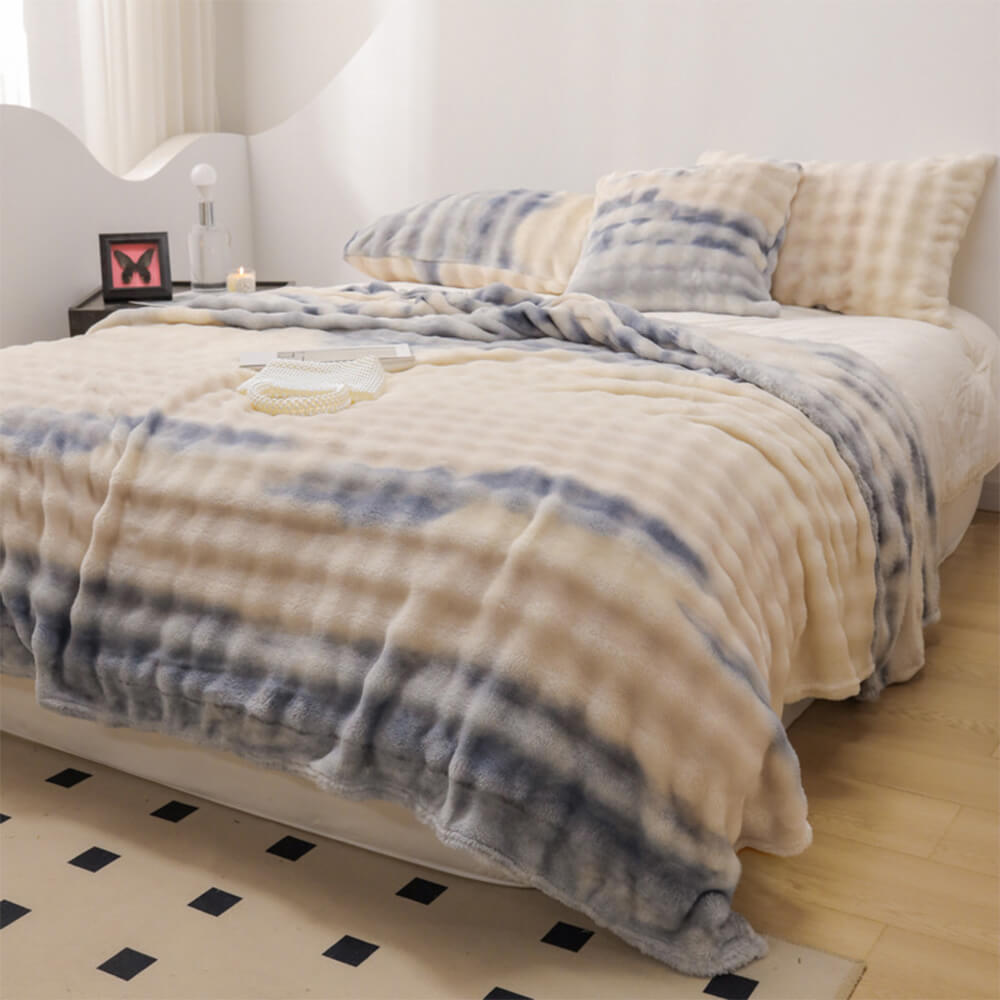 Luxury gradient faux fur throw draped elegantly over a modern bed