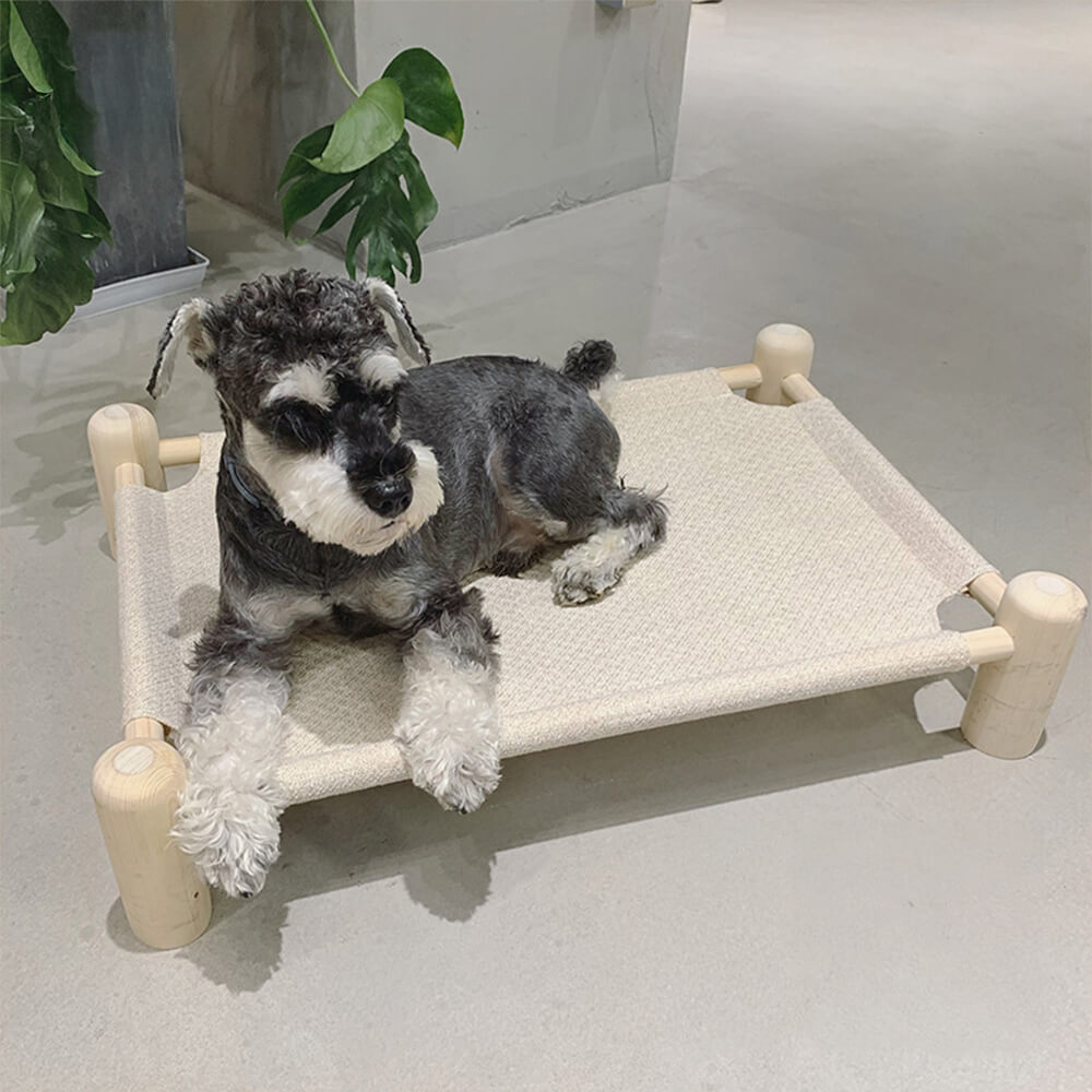 Scratch-resistant wooden elevated dog bed with linen fabric, shown in a living room setting