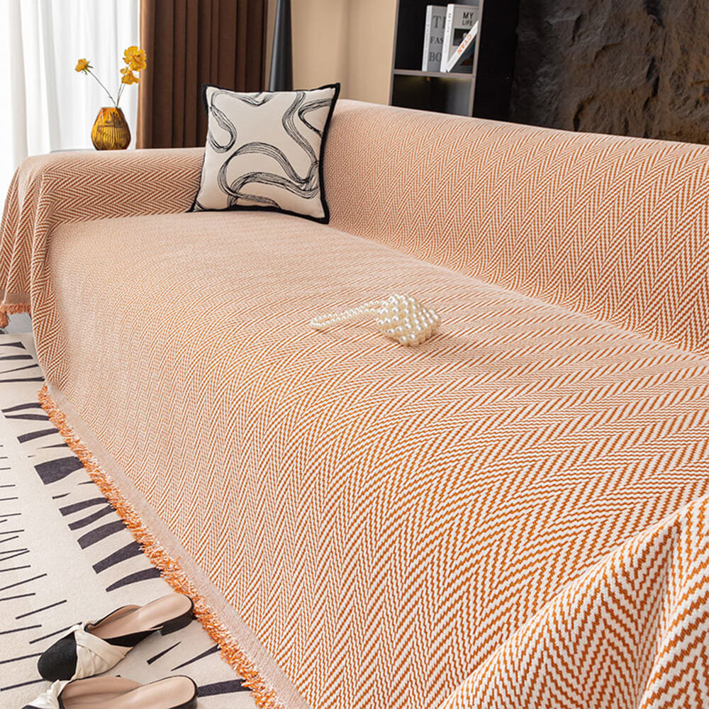 Luxury chenille herringbone couch cover draped elegantly over a neutral sofa, showcasing fringe detailing