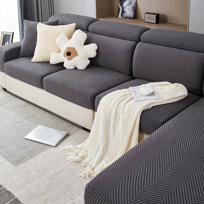 Herringbone couch cover being stretched over a sofa